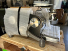 Slayer Espresso Single wrapped in protective paper on a wooden surface with a blurred background