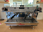La Marzocco coffee machine on a wooden floor with a window in the background