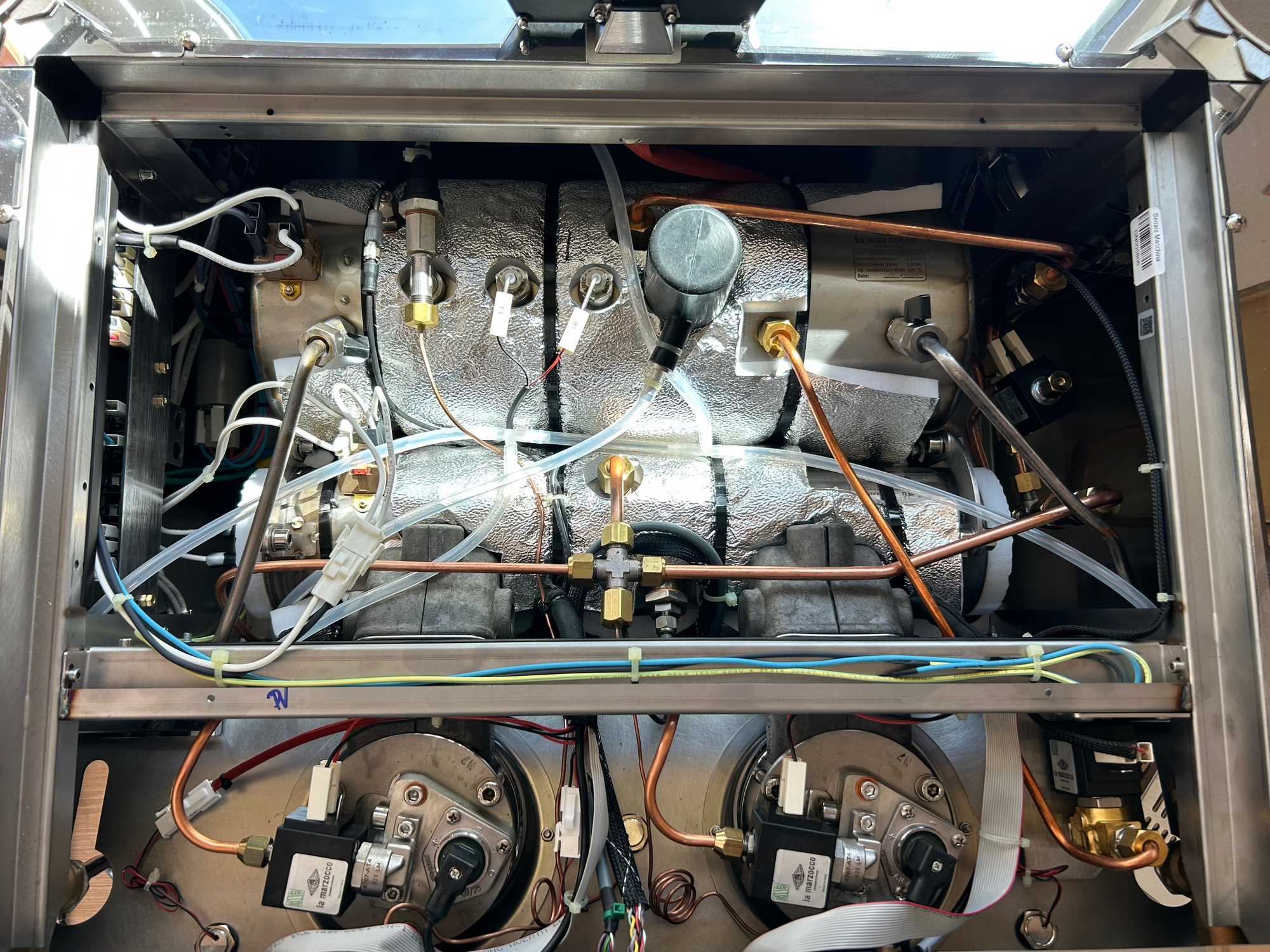 Close-up of a mechanical system with various components and wiring inside an GB5 ABR espresso machine