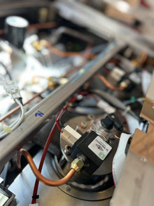 Close-up of a mechanical or electronic component with wires and a label.