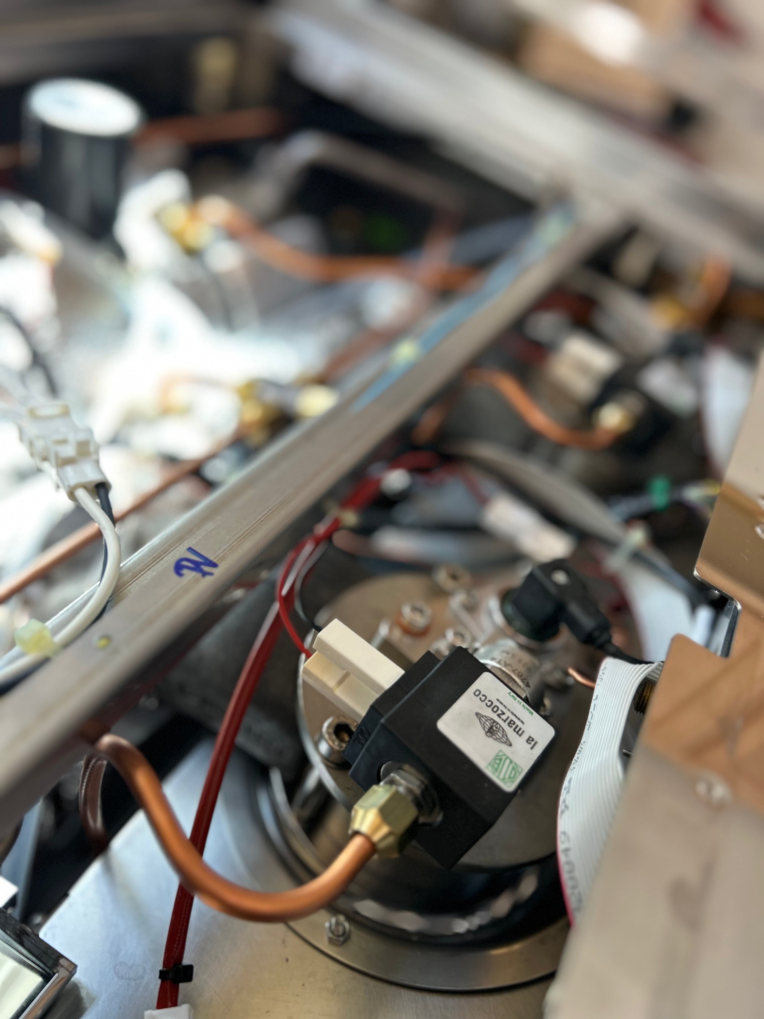 Close-up of a mechanical or electronic component with wires and a label.