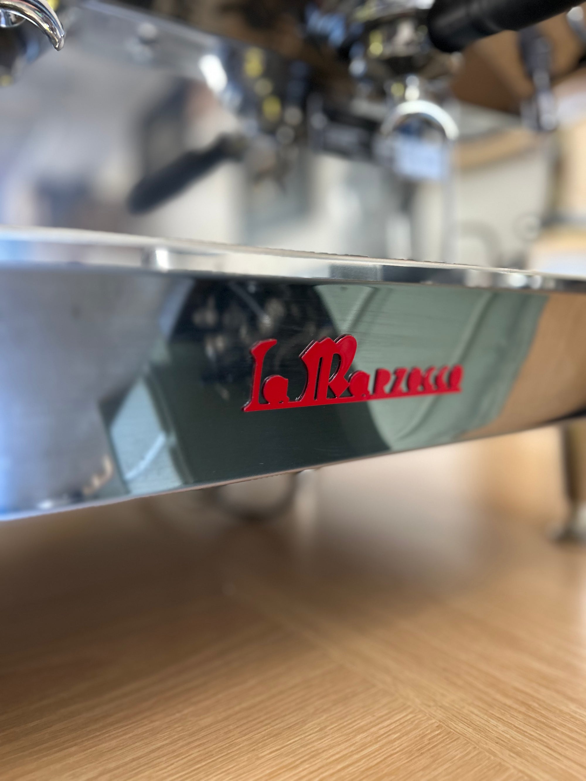 Close-up of a La Marzocco coffee machine with a red logo.